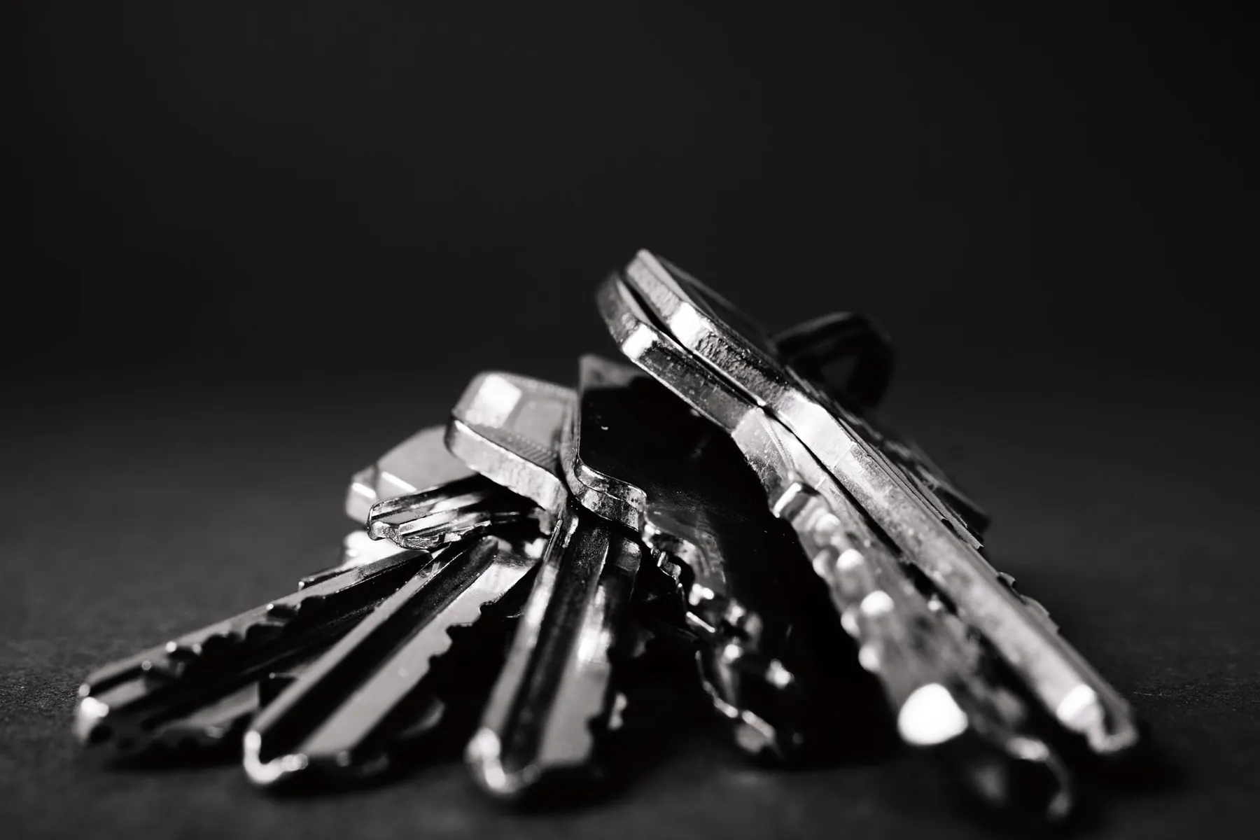 A bunch of metal keys on a dark surface.